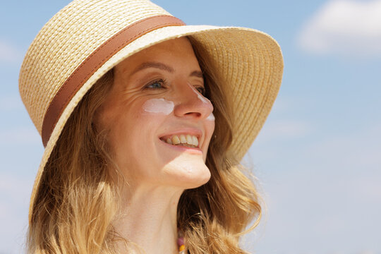 Woman Applying SPF Face Cream Outdoors for Sun Protection