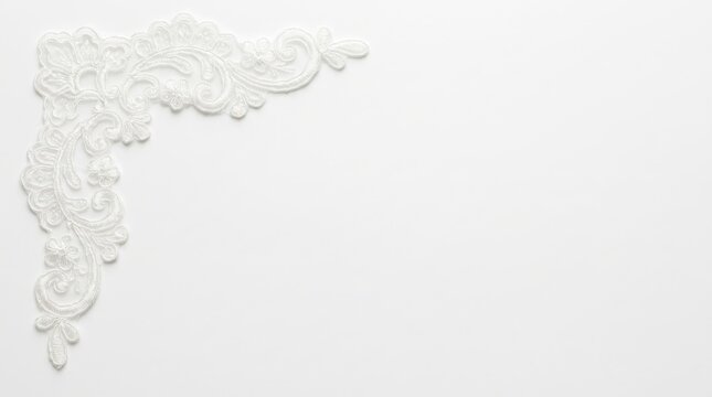 Elegant white lace corner embellishment with floral motifs on a plain background