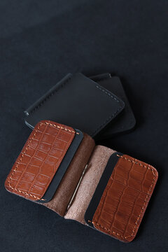 Handcrafted brown leather magnetic money clip wallet displayed on a black background. Minimalist slim cash holder with crocodile texture, premium craftsmanship and modern design.