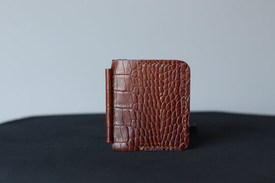 Brown leather magnetic money clip wallet with crocodile texture isolated on a clean background. Minimalist handcrafted cash holder with premium finish and modern everyday carry design.