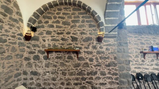Stone walls and prayer carpets inside the historic masjid shikhan.