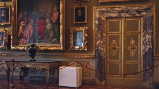 Blurred museum interior with ornate gilded paintings, decorative marble doorway and velvet rope barrier in soft bokeh; background backdrop copyspace calm.