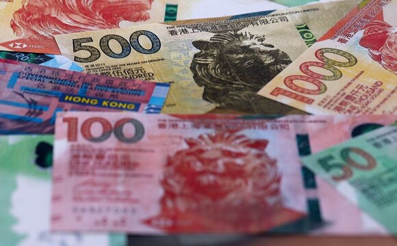 Hong Kong dollar money bills pile on table. Hong Kong banknotes of HKD currency close up.