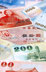 Fototapeta premium Taiwanese dollar money bills pile on table. Taiwan banknotes of TWD currency close up.