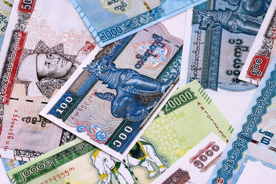 Myanmar kyat money bills pile on table. Myanmar banknotes of MMK currency close up.