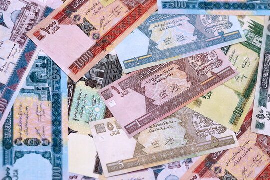 Afghan afghani money bills pile on table. Afghanistan banknotes of AFN currency close up.