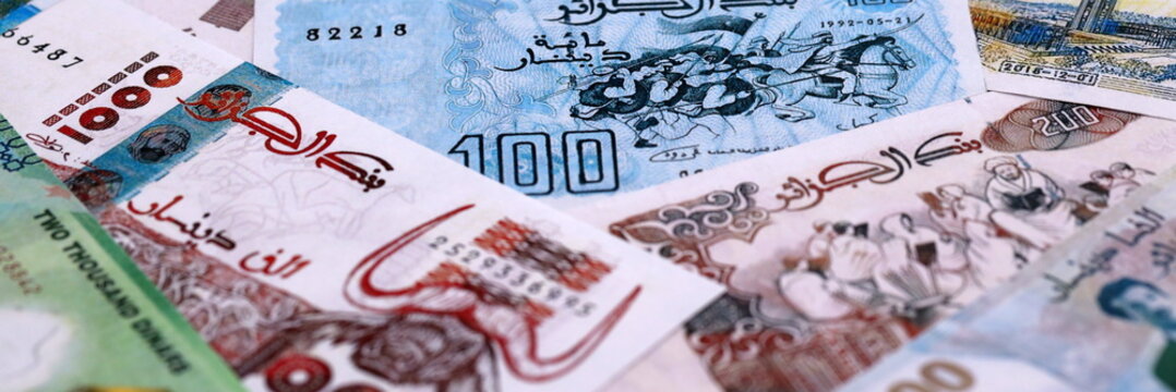 Algerian dinar money bills pile on table. Algeria banknotes of DZD currency close up.