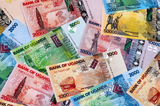 Ugandan shilling money bills pile on table. Uganda banknotes of UGX currency close up.