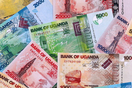 Ugandan shilling money bills pile on table. Uganda banknotes of UGX currency close up.