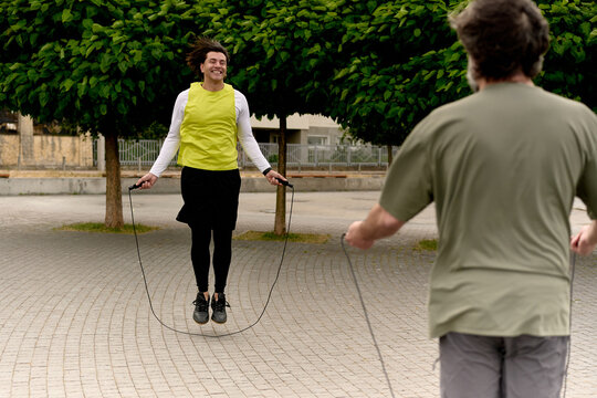 Father and son jumping rope together by the lake