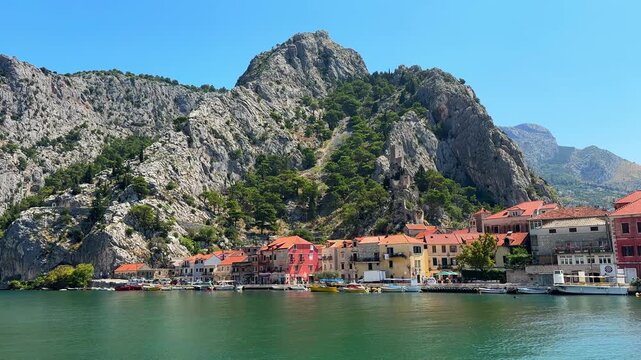 Scenic view of Omis town with historic fortress on the mountain cliff by the Cetina river in Croatia