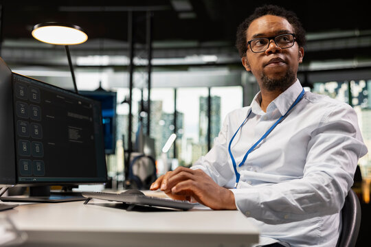 System administrator uses an AI chatbot to answer prompts and solve technical tasks with predictive technology, interacting with a large language model program on an office computer.
