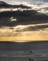 Obraz premium Crepuscular rays break through clouds over the open ocean