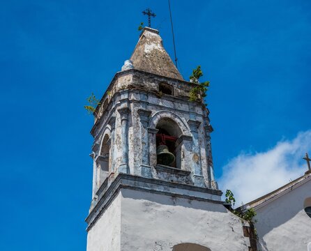 Weathered colonial church bell tower against a blue sky