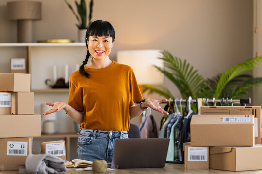 Woman small business owner packing orders in home office for online shop, smiling entrepreneur