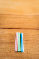 Fototapeta premium Creative educational design concept: colored pencils and chalk for back to school with a wooden table background