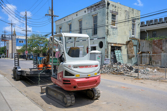 New Orleans, LA, USA - July 5, 2026:Takeuchi Mini Excavator and Trailer Next to Building Being Demolished for Construction Project in Central City Neighborhood