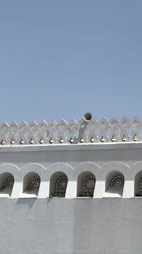 Bright exterior view of the white dome and minaret of Masjid Al Qiblatain in Medina.