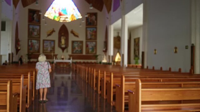 Blurred church interior with shallow bokeh, soft out of focus pews and altar and stained glass reflections church; background backplate calm.