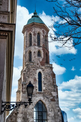 Obraz premium Historical tower stands tall against the blue sky with birds flying nearby in a city setting during the day