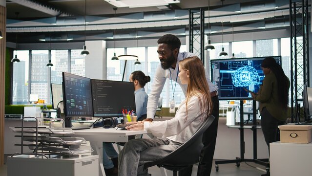 Startup office manager congratulates a young developer after she builds artificial intelligence models for business analytics, celebrating successful work with a fist bump and team recognition.