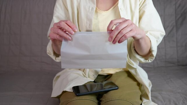 Woman putting smartphone into waterproof zipper bag. Careful woman placing her mobile phone inside a translucent waterproof pouch for protection, zipping it securely to keep it safe from water