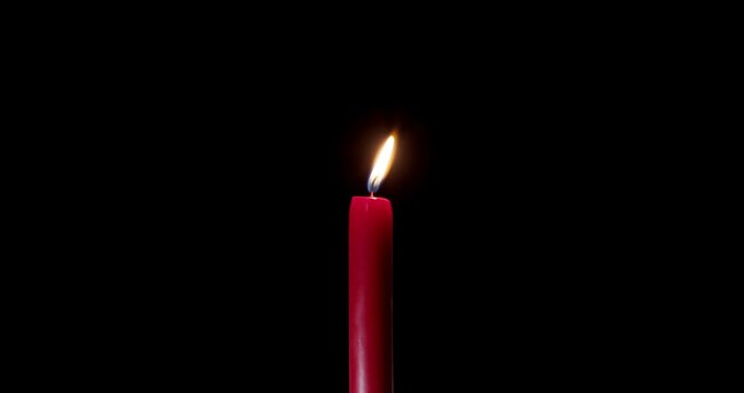 Tall red candle burning steadily in a quiet dark room. The clean flame of this wax candle cuts through shadows. This glowing candle symbolizes faith, peace, and festive overlay design.