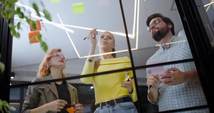 Team brainstorming session in a modern office with sticky notes and whiteboard markers in clear view