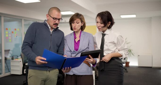 Team members discuss plans in office setting showcasing collaboration among business professionals in modern workspace