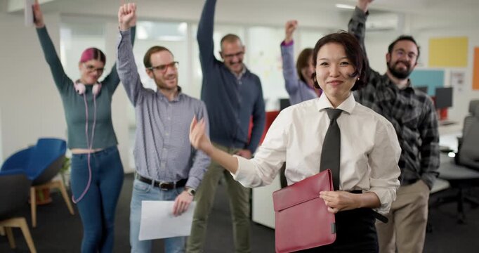 Team celebrates success in the office as businesswoman shares achievements with colleagues in a lively atmosphere during the workday