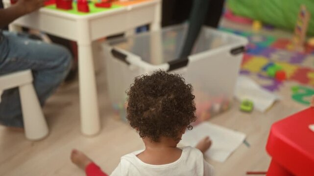 Woman and boy building a tall block tower on a play table inside a building classroom; early learning joy.