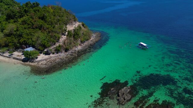 Palawan island hopping with tourists snorkeling in clear water. Lovely aerial view drone