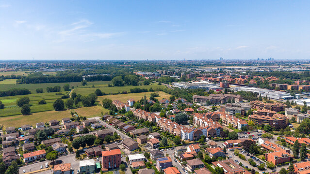 Aerial View of Suburban Neighborhood: A sprawling residential area with rows of houses and apartment buildings sits under a clear blue sky, Bellaria, Peschiera Borromeo, Italy