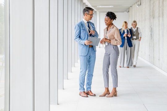 Engaging conversation in modern office hallway