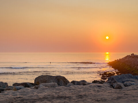 Golden sunset over rocky beach in Furadouro Ovar