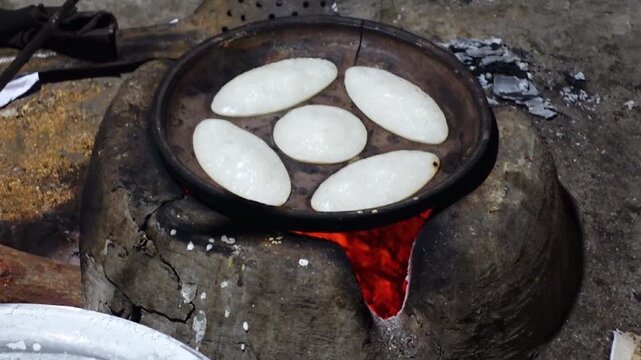 Rice powder are mixed with water and salt and poured into a terracotta mold, which is then cooked in a heated clay oven to make Chitai Pitha.