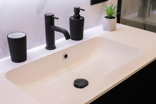 White bathroom sink with black faucet