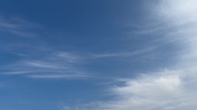 Wispy Cirrus Clouds Drifting Across Deep Blue Sky with Spacious Copy Space