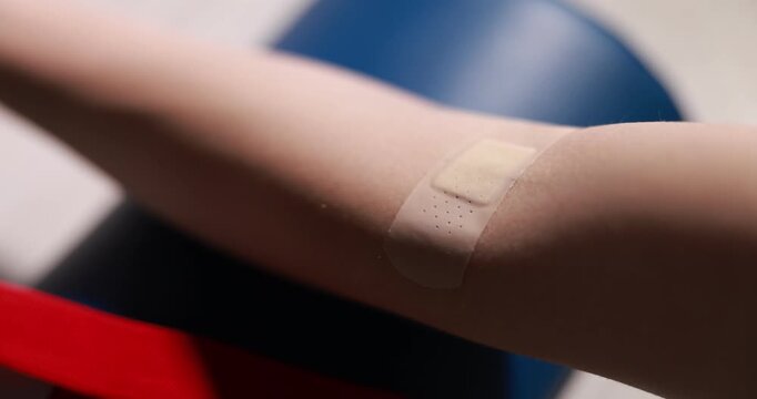 Blood analysis. Laboratory worker applying medical bandage on woman's hand, closeup. Camera moving