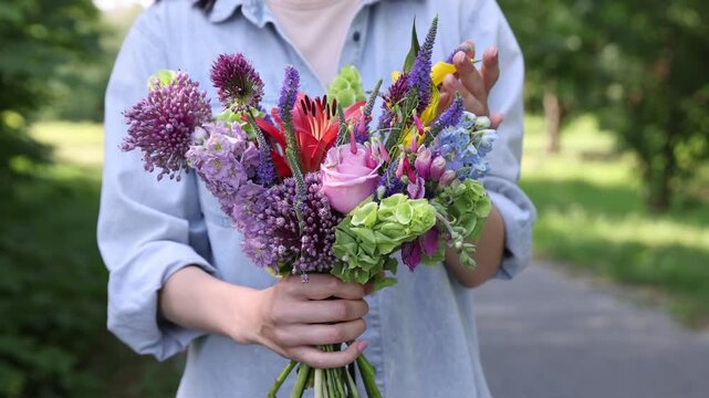Woman with bouquet of beautiful summer flowers outdoors, closeup