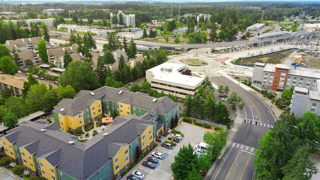 Transit station development zone and urban commercial blocks intersect near S 317th Street corridors. Overhead capture highlights light rail, parking garage, solar panels. Federal Way, WA