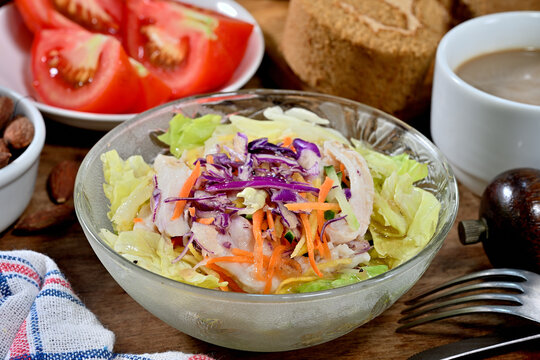 Shredded chicken salad with scallion and sald dressing in glass bowl