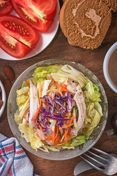 Shredded chicken salad with scallion and sald dressing in glass bowl