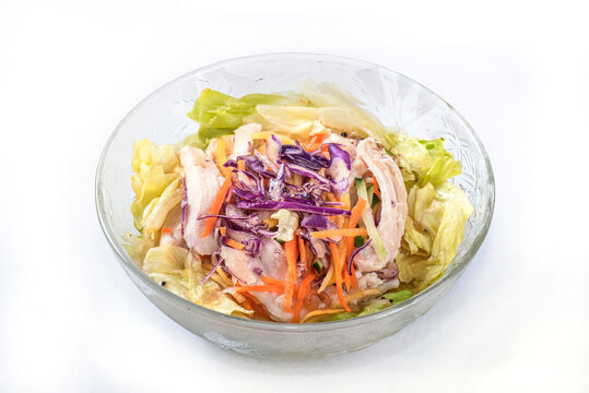 Shredded chicken salad with scallion and sald dressing in glass bowl