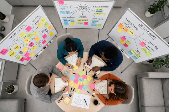 Diverse team brainstorming strategy on whiteboards with sticky notes, top view, suitable for business meetings, project planning and startup ideation
