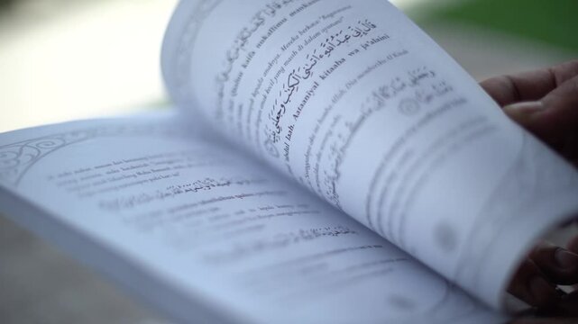 Slow Motion Close-up of Hands Holding and Opening the Holy Quran