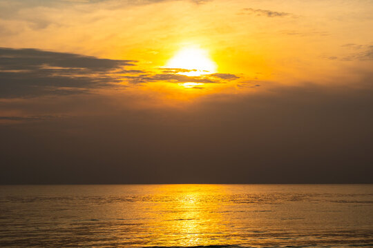 Nature sky panoramic scenic view of a vibrant sunset or sunrise sky with glowing orange and yellow clouds transitioning into deep blue twilight, representing nature beauty, and tranquility at ocean