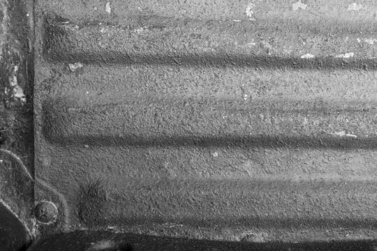 High contrast close up texture of an old industrial rusted metal surface with chipped blue and red paint layer