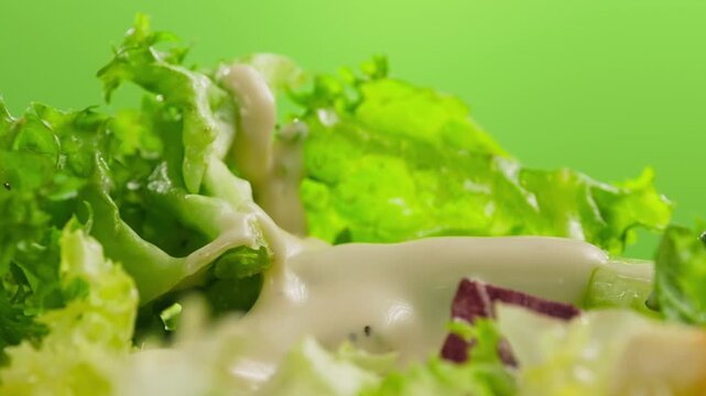 Caesar Dressing or Creamy Sauce Pouring Over Fresh Green Caesar Salad Leaves in Bowl, Close Up of Healthy Food Preparation, Restaurant and Cafe Cooking Concept