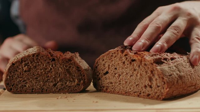 Black rye bread close up, cutting with knife dark brown sliced loaf, borodinsky slavic food, square slices with coriander on white background, baker with tasty healthy fresh bread.